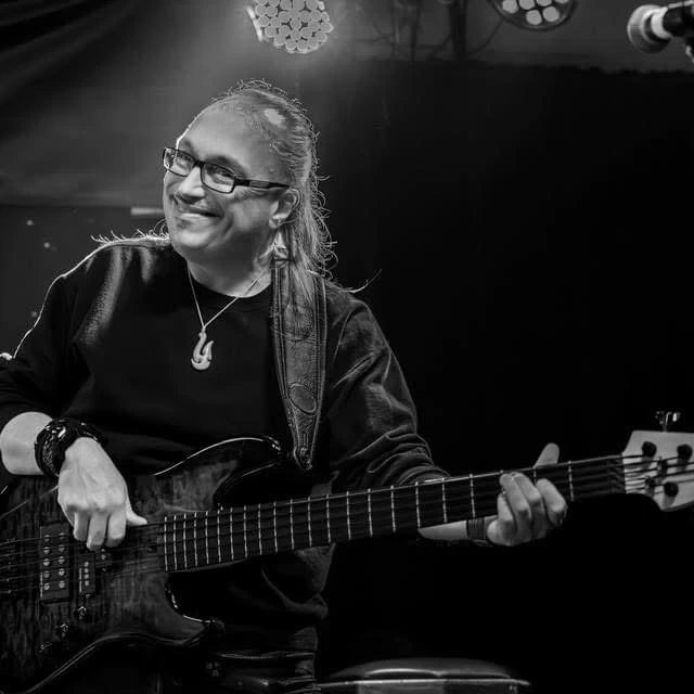 image of Timmer Blakely playing the bass on stage and smiling